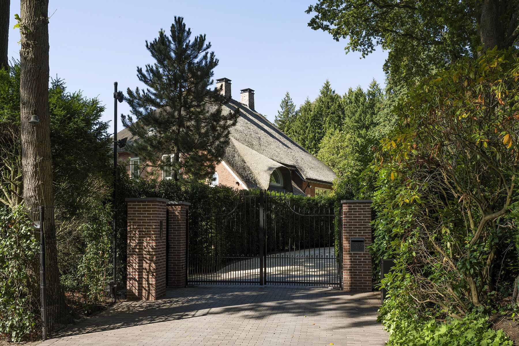 Smeedijzeren toegangspoort met klinkeroprit
